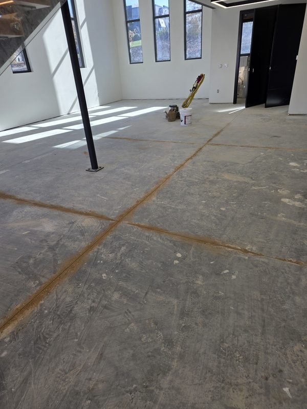 Bare concrete open space before flake epoxy installation, with adjacent glass staircase, Lake Norman NC