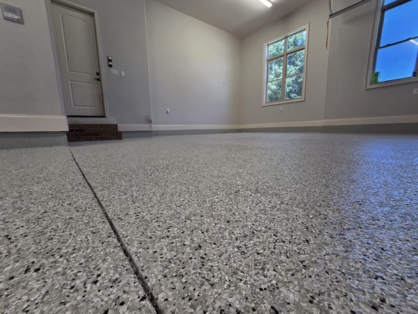 Low-angle view of finished garage flake epoxy floor with window light, Lake Norman NC